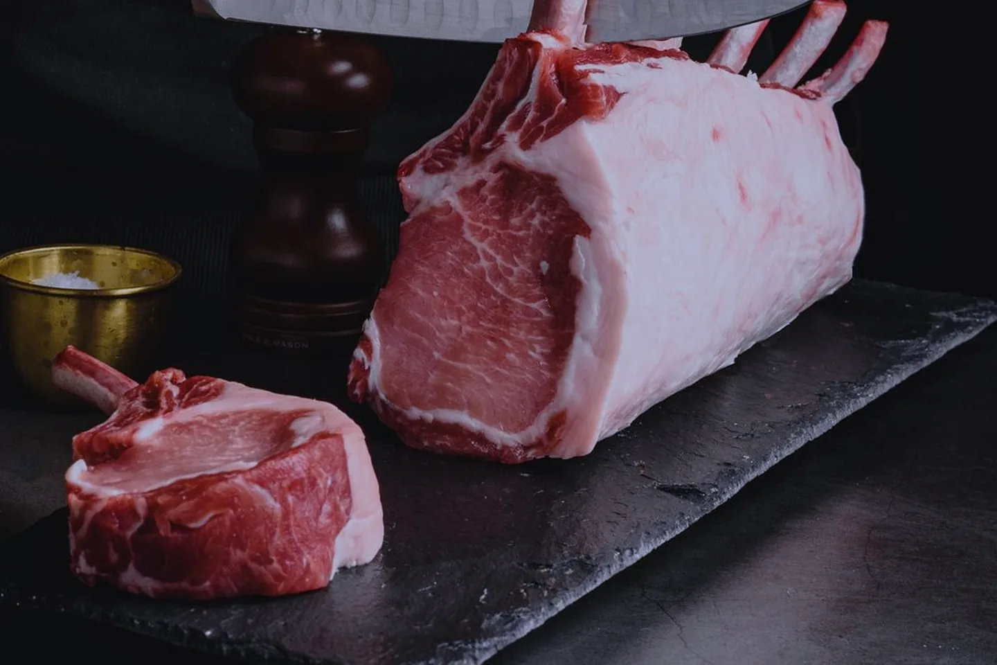 Rack de carne ibérica con marmoleo sobre tabla de pizarra